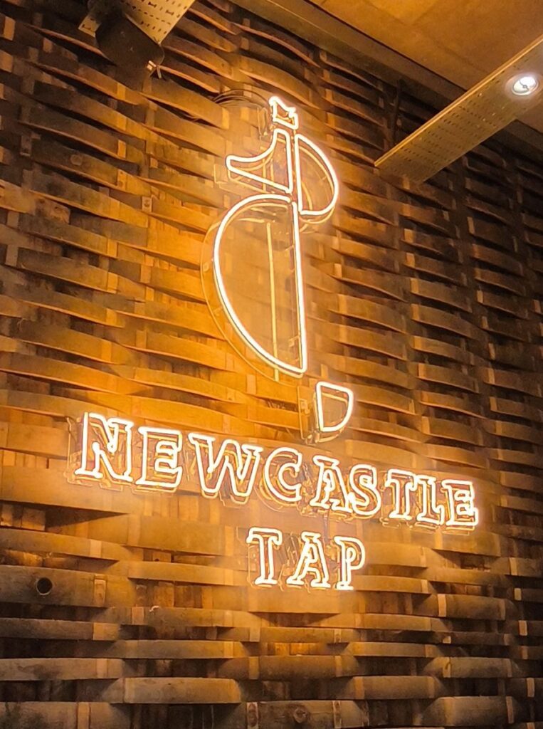 Newcastle Tap logo inside the Newcastle Tap Bar