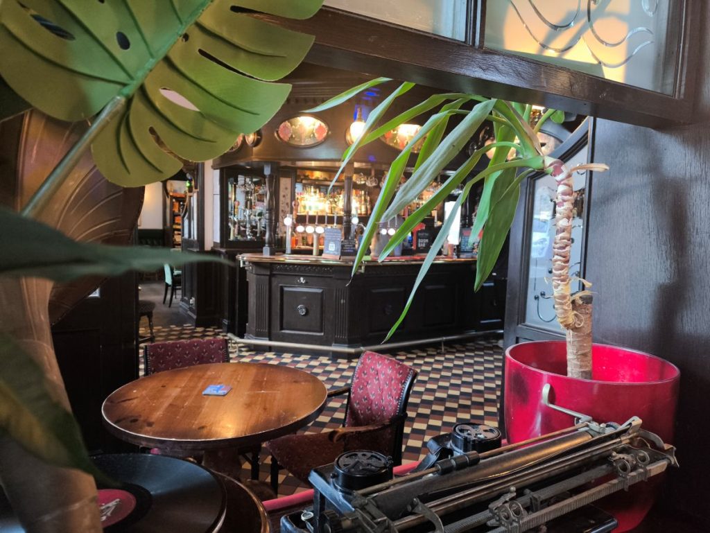 Interior of the Carriage Pub in Jesmond Newcastle showing the bar, seating and plants.