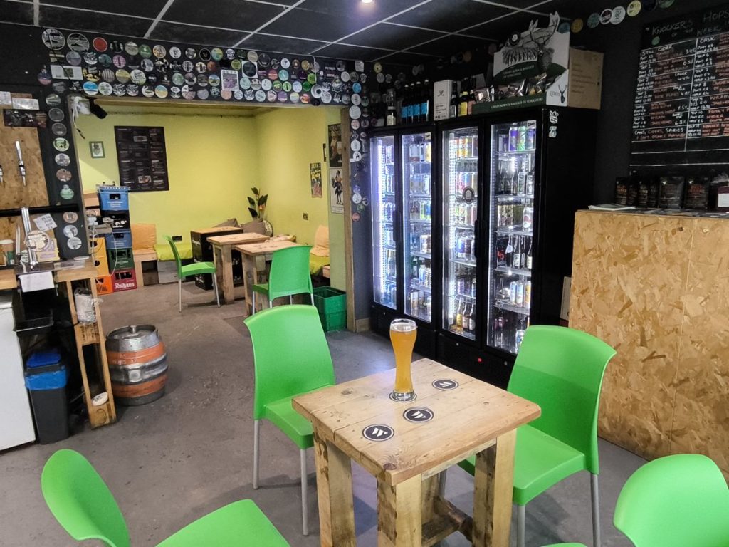 The Hop Knocker, Sunderland Road, Durham showing seating and fridges with a beer on the table in the foreground