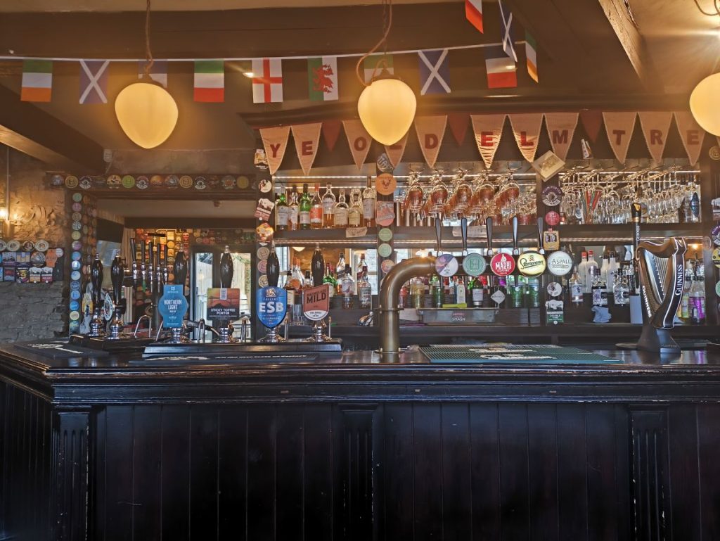 The bar at Ye Old Elm Tree on Crossgate, Durham showing beer pumps and flags