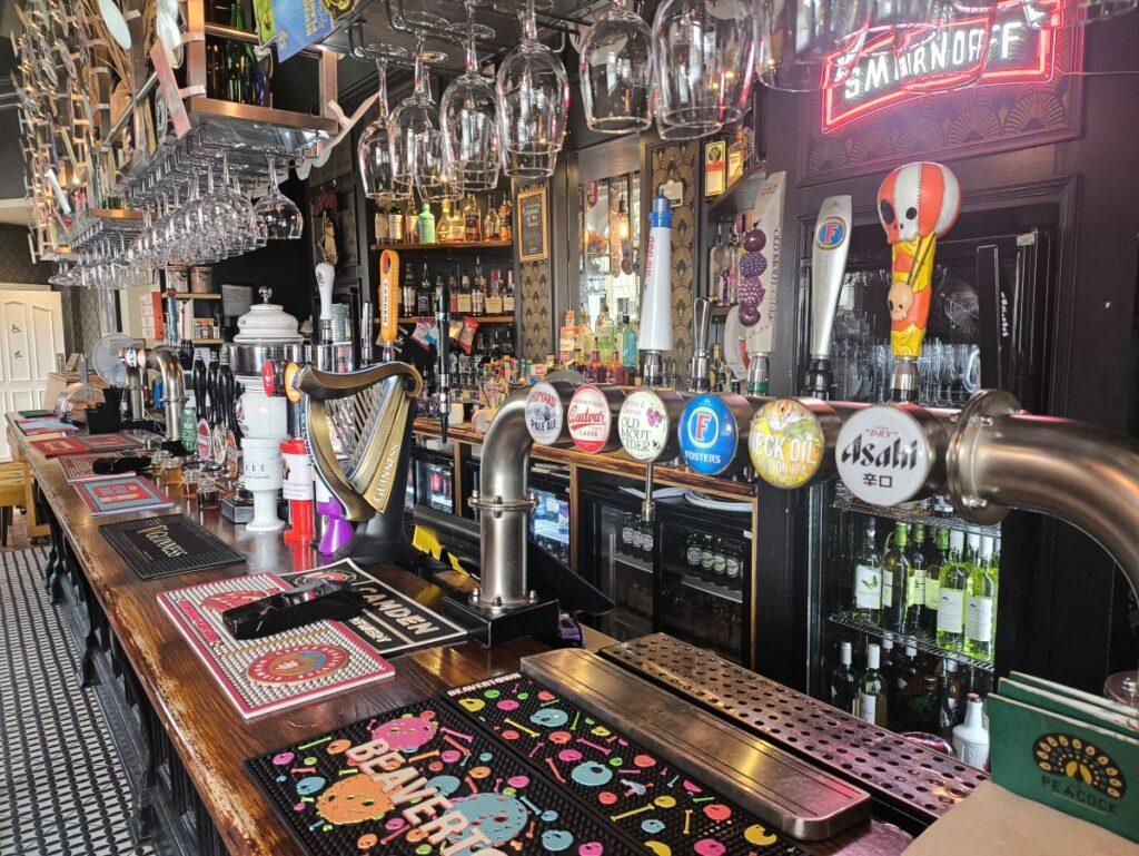 The bar of The Peacock pub in Sunderland showing assorted pumps and glasses