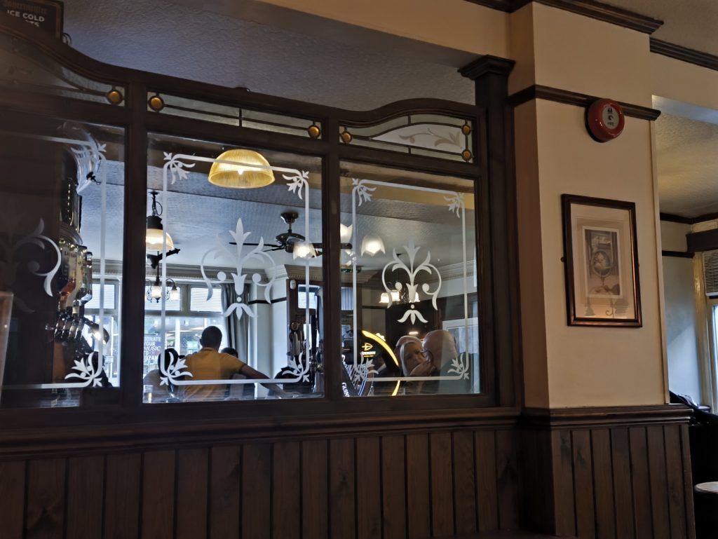 Looking through to the bar from the snug of The Globe in Hexham.  The view is through a decorative glass screen