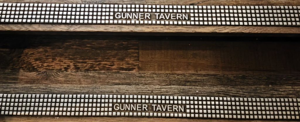 Decorative stairs at the Gunner Tavern Newcastle showing the name of the pub picked out in the metal anti-slip treads