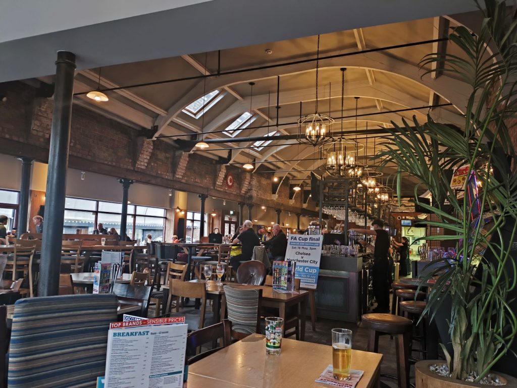 Interior of the Wetherspoon pub The High Main, Byker, Newcastle showing tables and the attractive wood beamed ceiling.