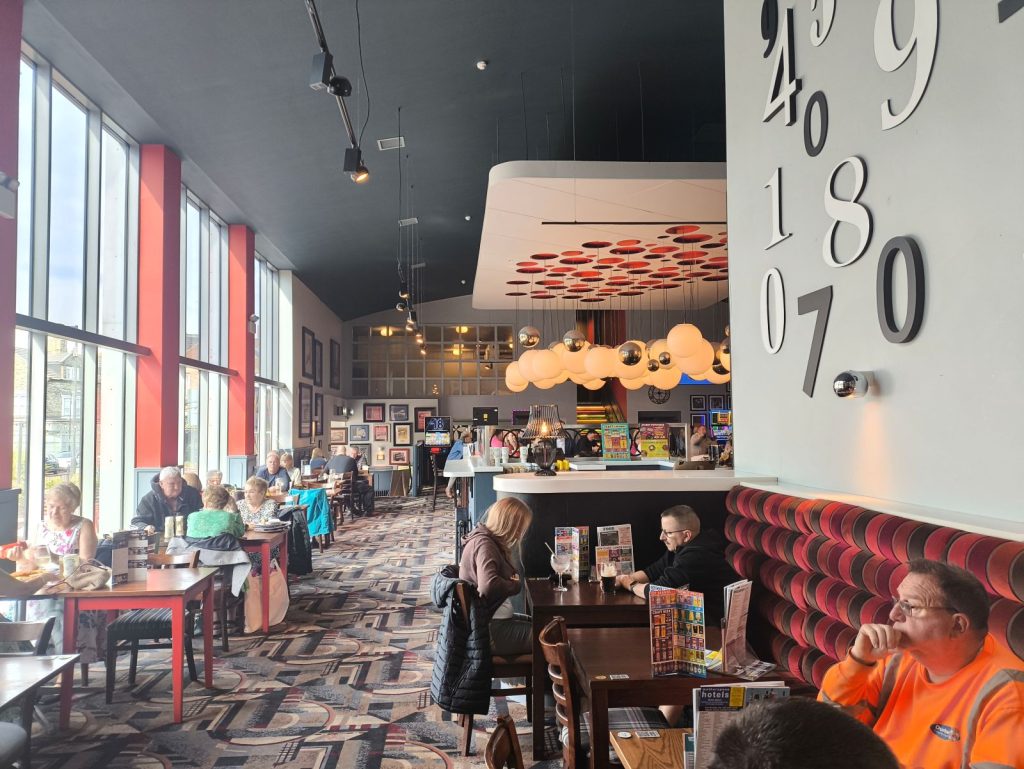 The inside of the Grand Electric Hall Wetherspoons in Spennymoor County Durham showing large picture windows and the bright interior.