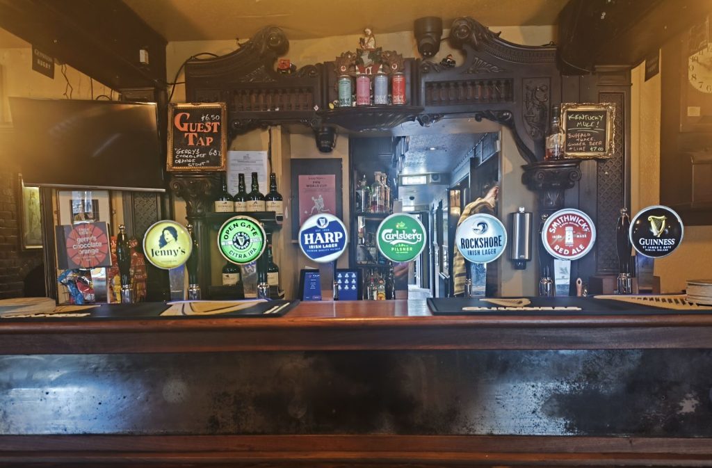 The bar of the Jenny Watts pub in Bangor showing the beer pumps with two Out of Office Brewing beers.