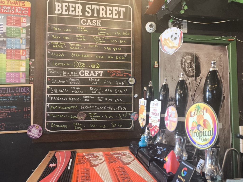 The beer board and bar at Beer Street Newcastle also showing the cask ale pumps on the bar.