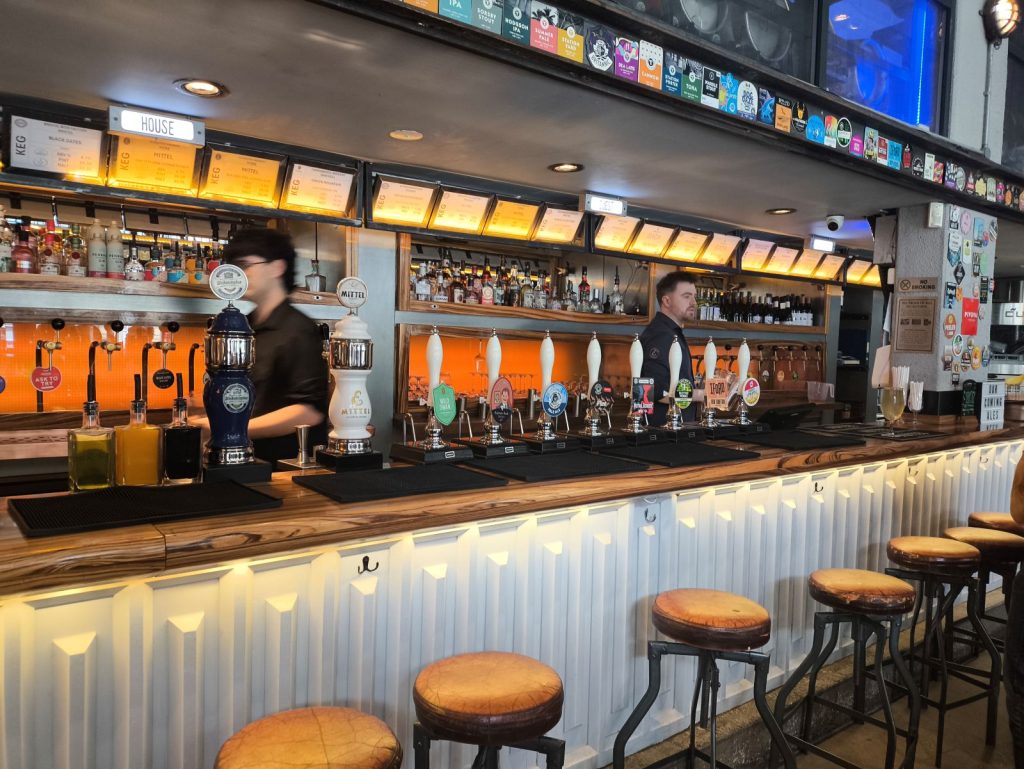 The long bar at the Newcastle Tap showing the extensive range of cask and keg beers.